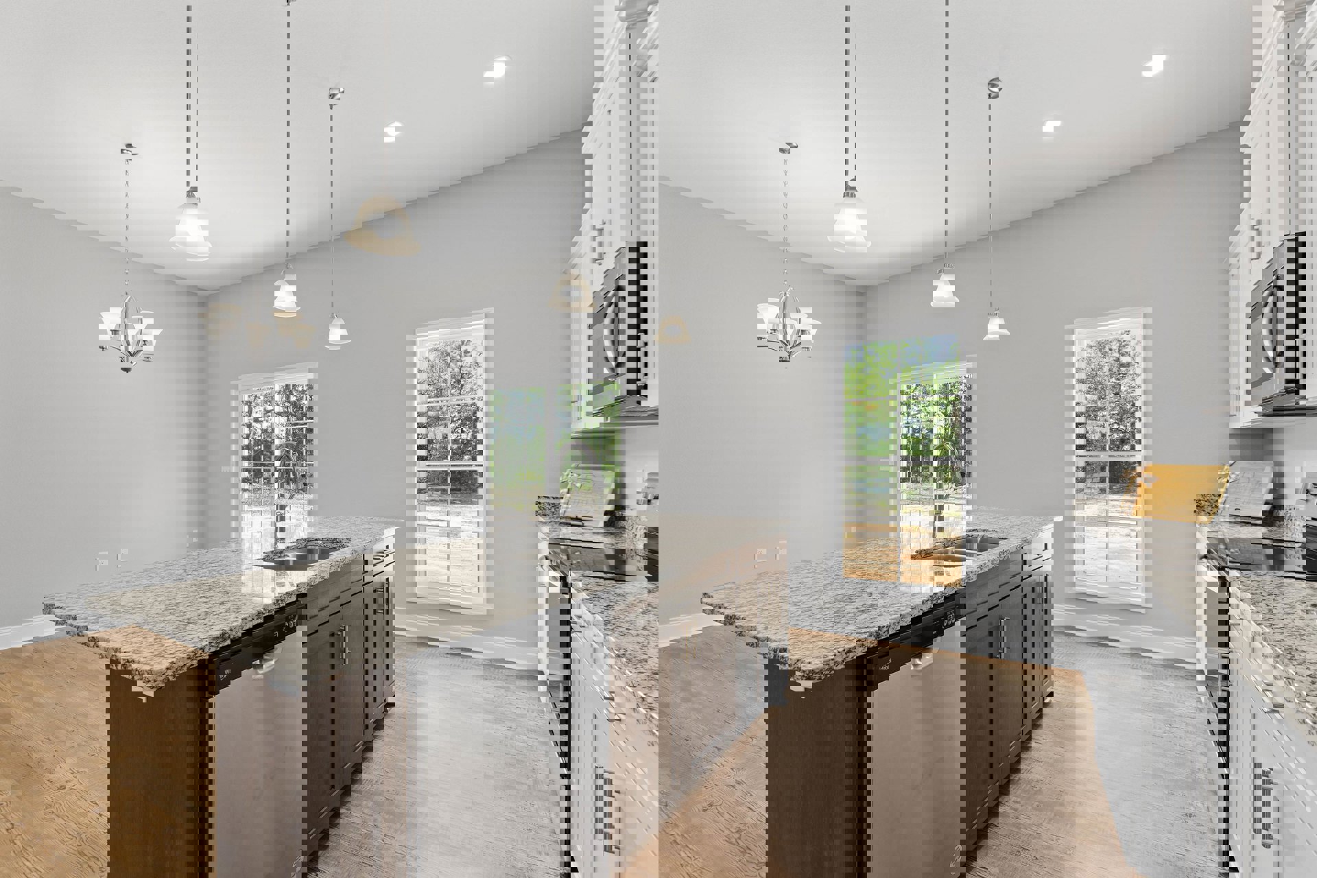 Granite countertop kitchen with stainless steel sink, wood cabinetry, built-in dishwasher, pendant light fixture, and window overlooking trees