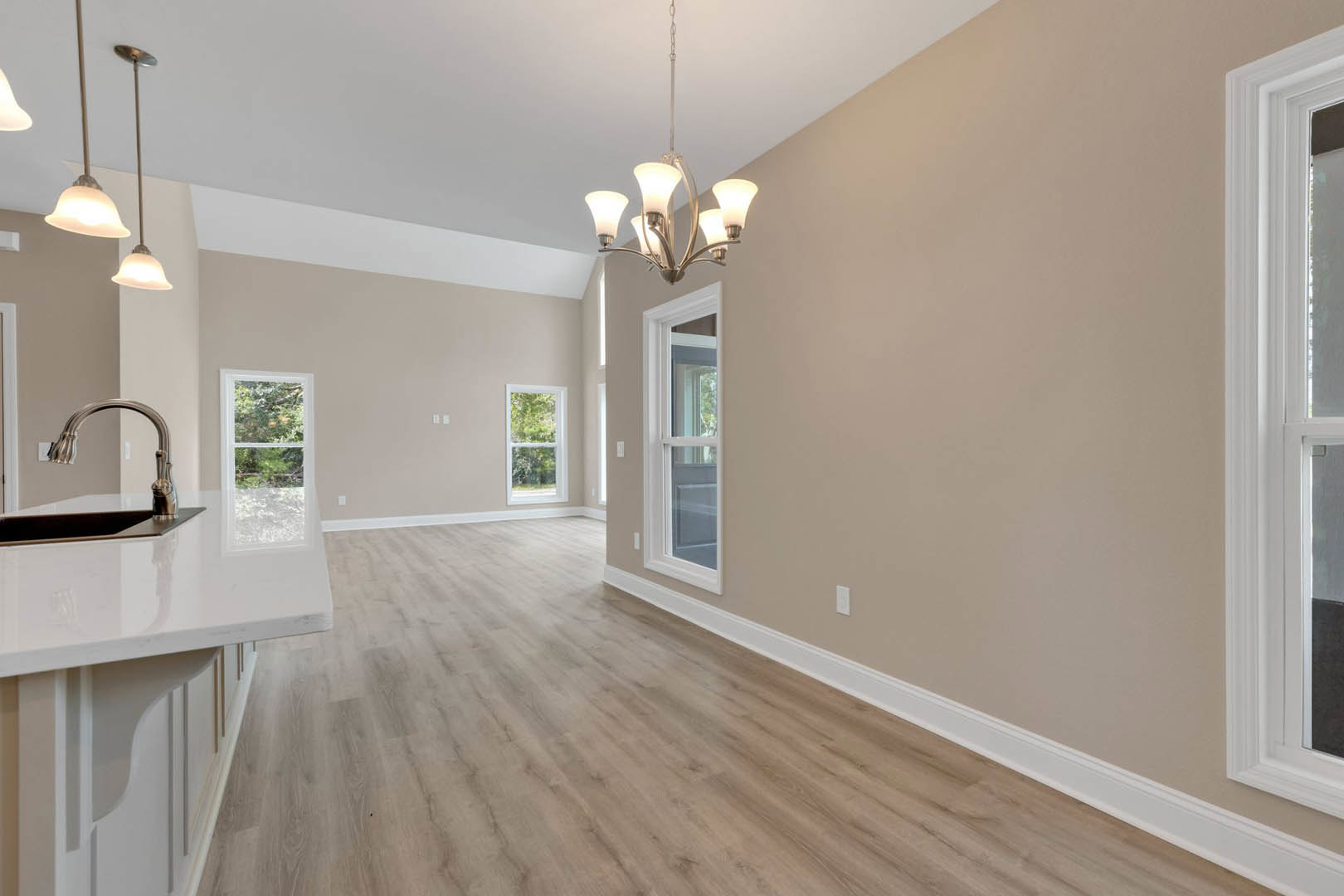 Wood floor room with white-framed window, modern chandelier, and neutral walls