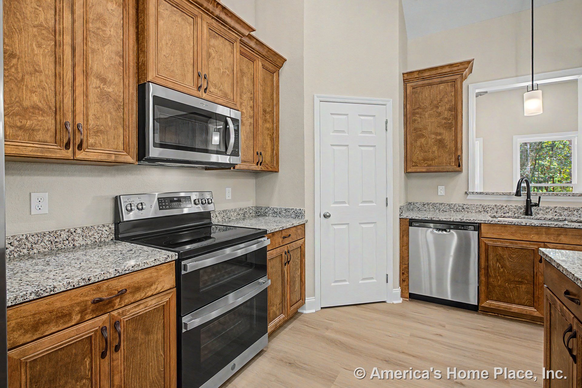 Granite countertops with wood upper and lower cabinets, stainless steel double oven and built-in microwave, under-counter dishwasher, pendant light fixture above island, pantry