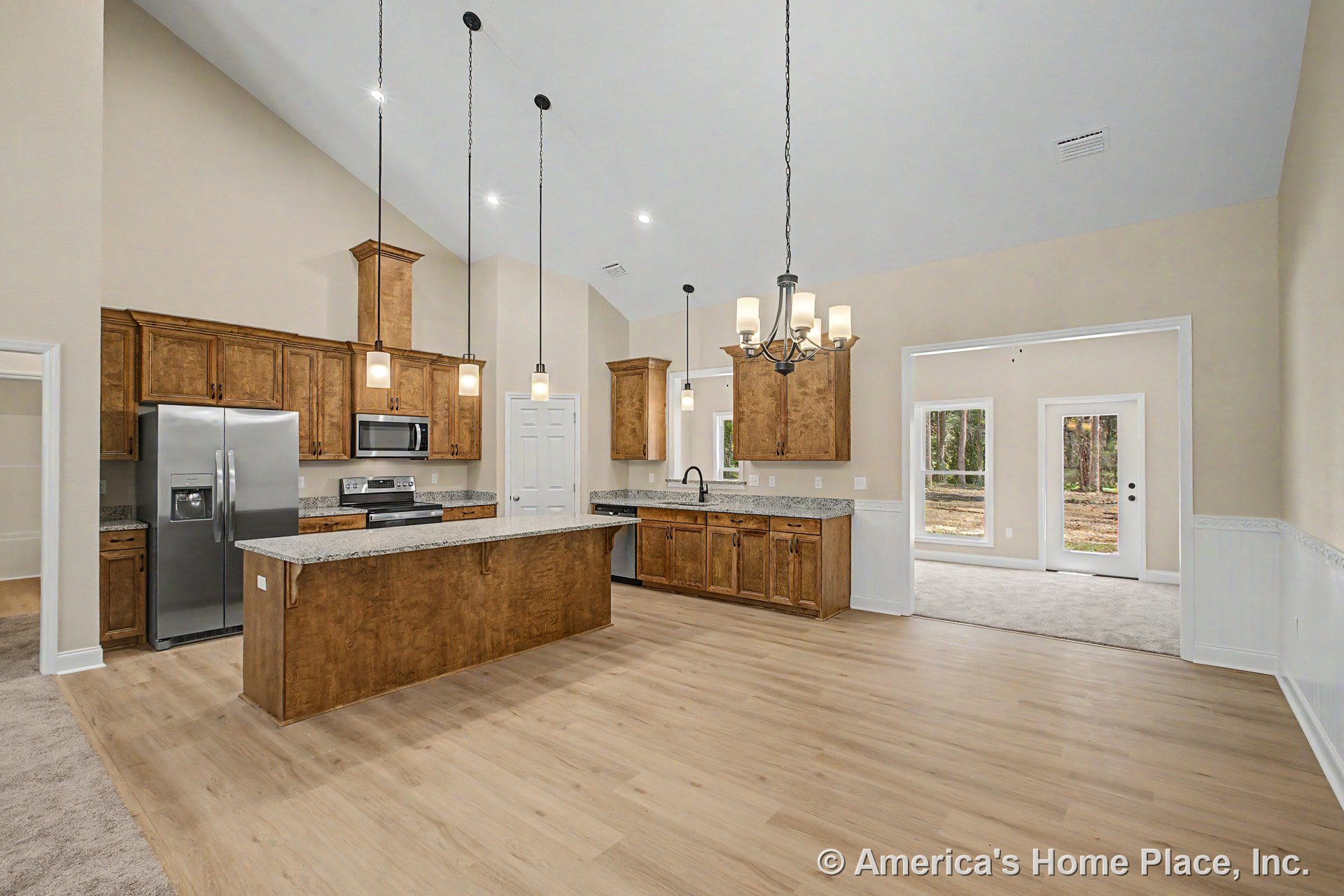 Wood kitchen cabinetry with granite countertops and stainless steel refrigerator beneath vaulted ceiling, pendant and chandelier lighting, open floor plan, hardwood flooring, and