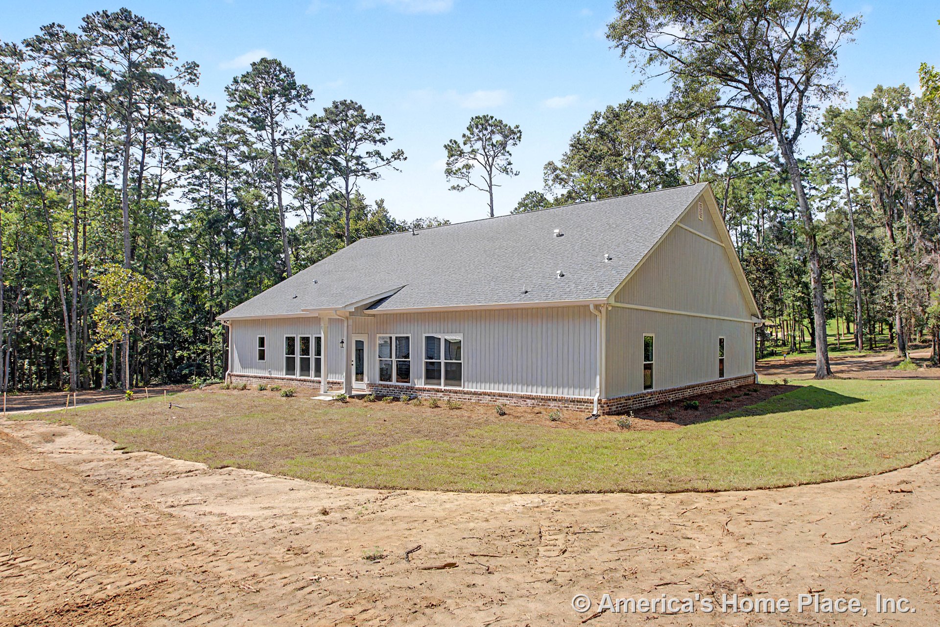 Light gray vertical siding exterior with brick foundation, covered entry porch, multiple large windows, gray shingle roof, and white trim accents on a single-story new construction
