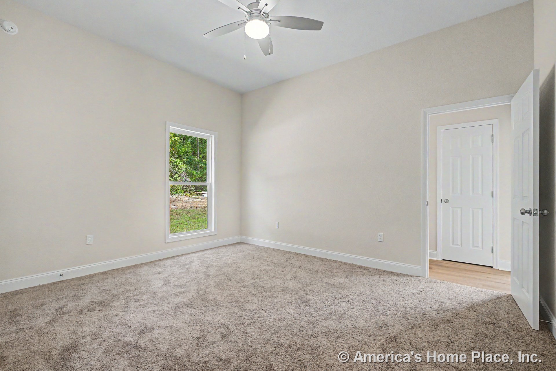 Bedroom with neutral carpet flooring, white trim and baseboards, single window, ceiling fan with built-in light, soft neutral wall color, and double doors.
