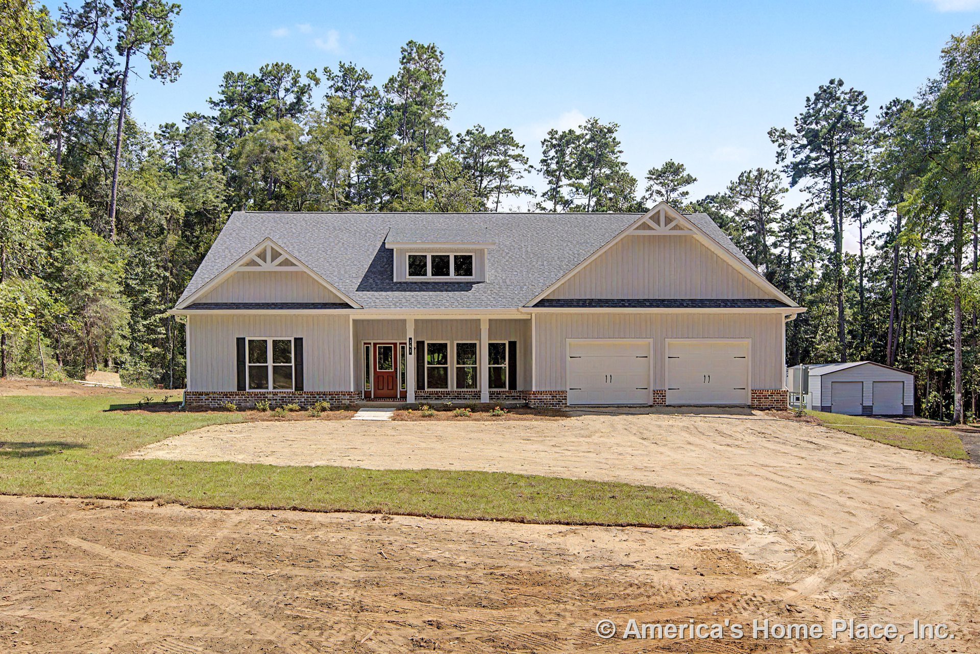 Covered front porch with brick foundation trim, board and batten siding, gable roof featuring a dormer window, two-car garage with carriage-style doors, double front door with