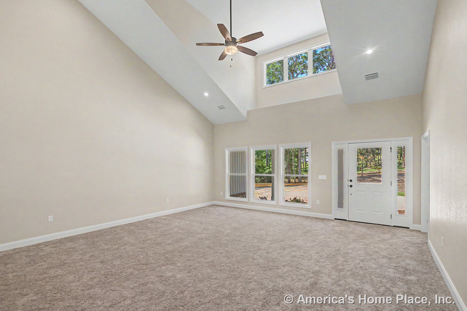 Vaulted ceiling with ceiling fan and recessed lighting, multiple large windows along a window wall, carpeted floor, white trim and baseboards, entry door with glass panels, neutral