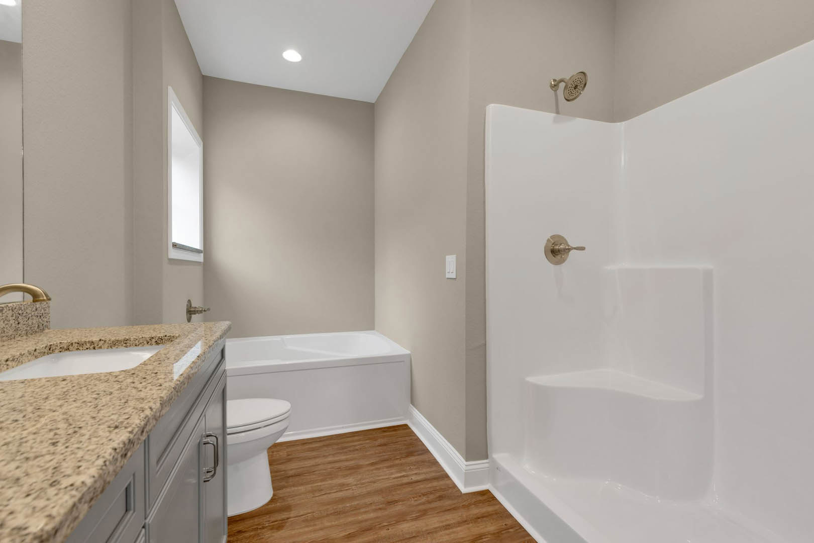 Bathroom with white tile walls, built-in tub, granite countertop vanity, chrome fixtures, ceiling light, and rectangular window.