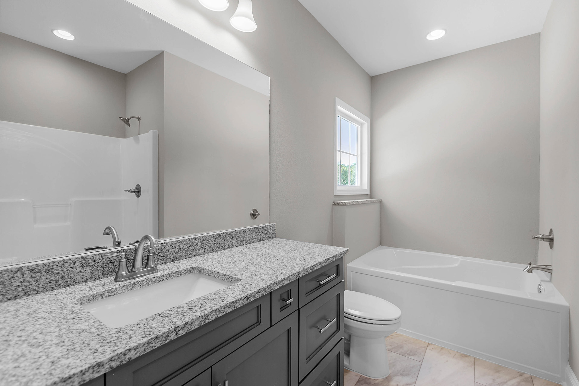 Modern bathroom with white ceramic sink, chrome faucet, toilet, and tiled walls