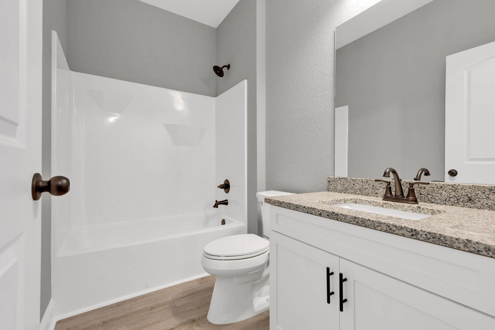 Modern bathroom featuring a white porcelain sink with chrome faucet, white toilet, light gray tile flooring, and smooth white walls.