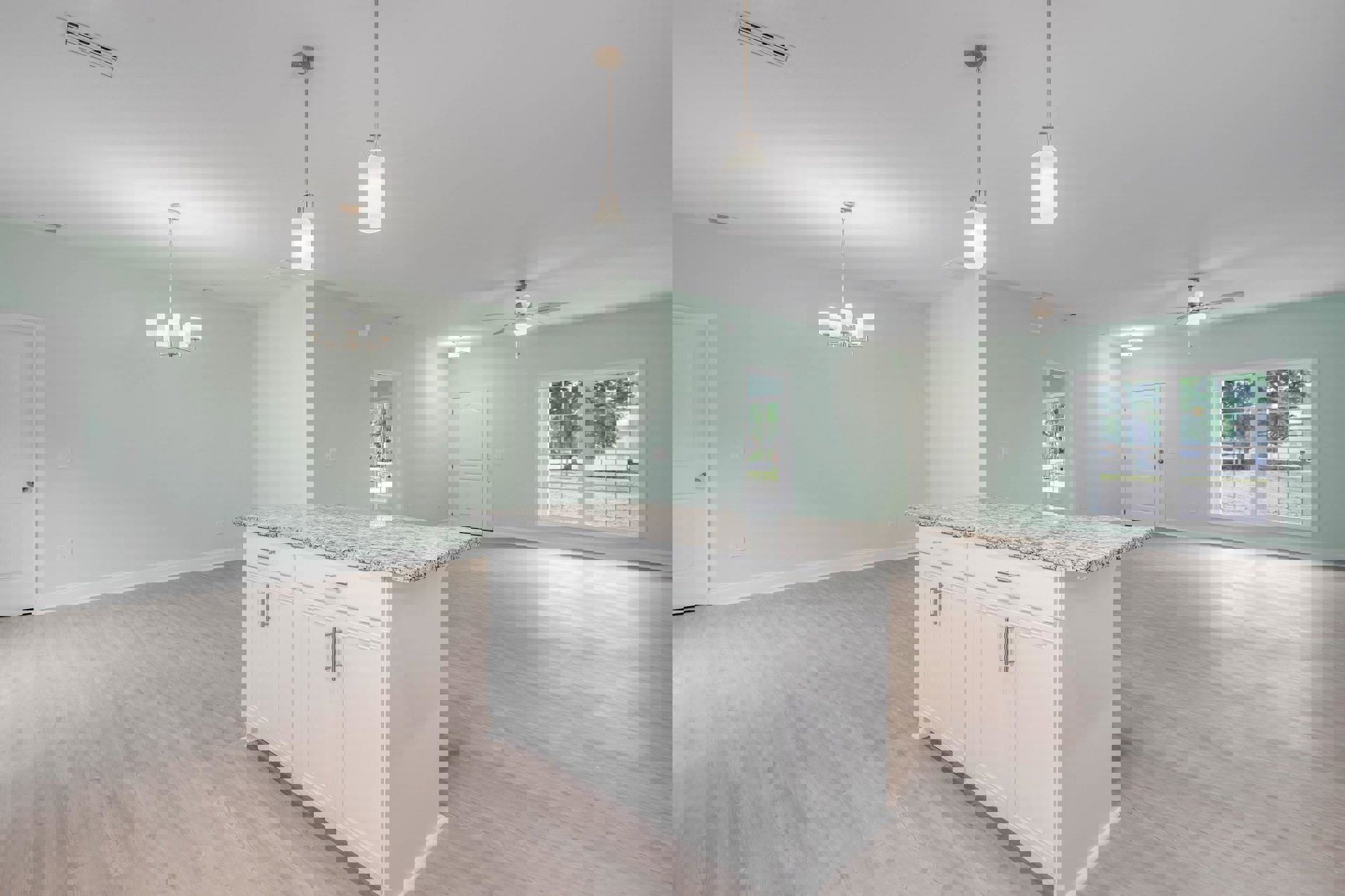 White kitchen island with marble countertops, stainless steel sink, paneled cabinetry, multi-pane window, white door with silver knob, light fixture above, hardwood flooring, and