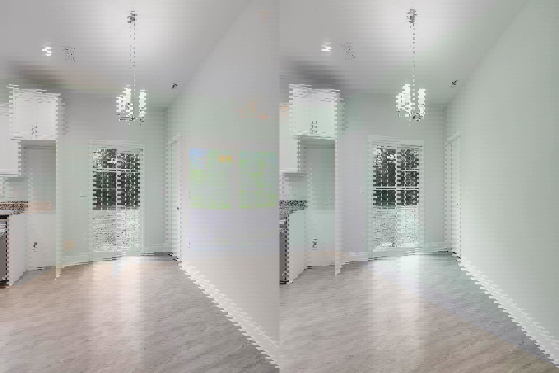 White sliding glass door and adjacent white door with silver handle, light wood laminate flooring, window, four-light chandelier, and neutral plaster walls in a modern kitchen