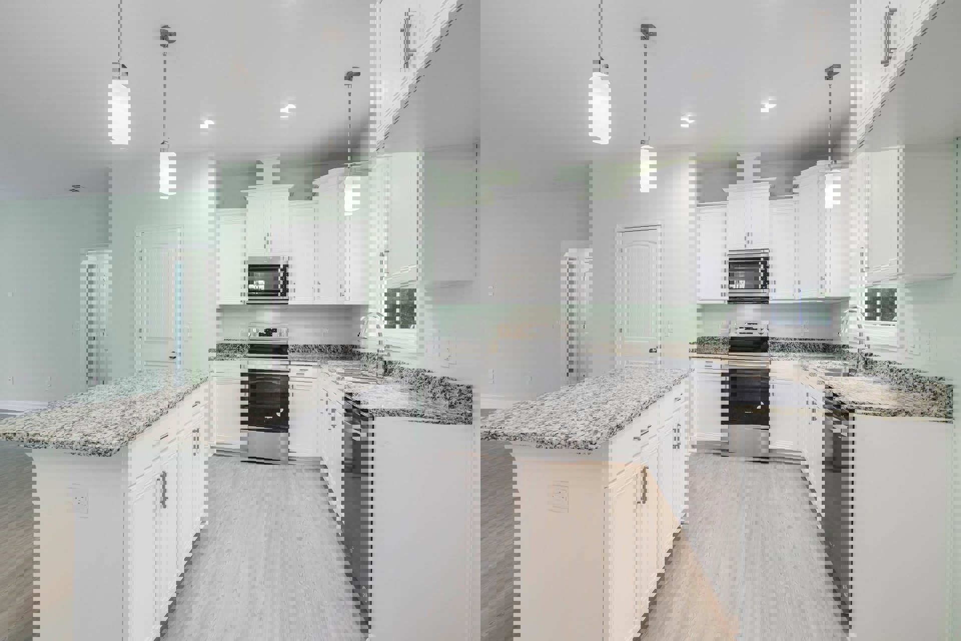 White kitchen with granite countertops, stainless steel microwave, close-up of stove, white island, paneled white door, and built-in cabinetry