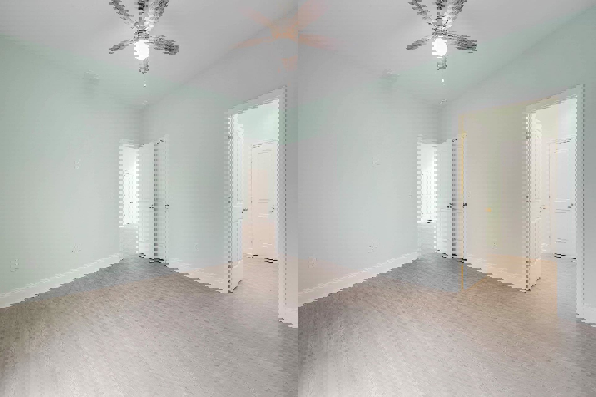 Ceiling fan with light fixture, white double doors with silver handles, laminate flooring, white plaster walls, and smooth white ceiling