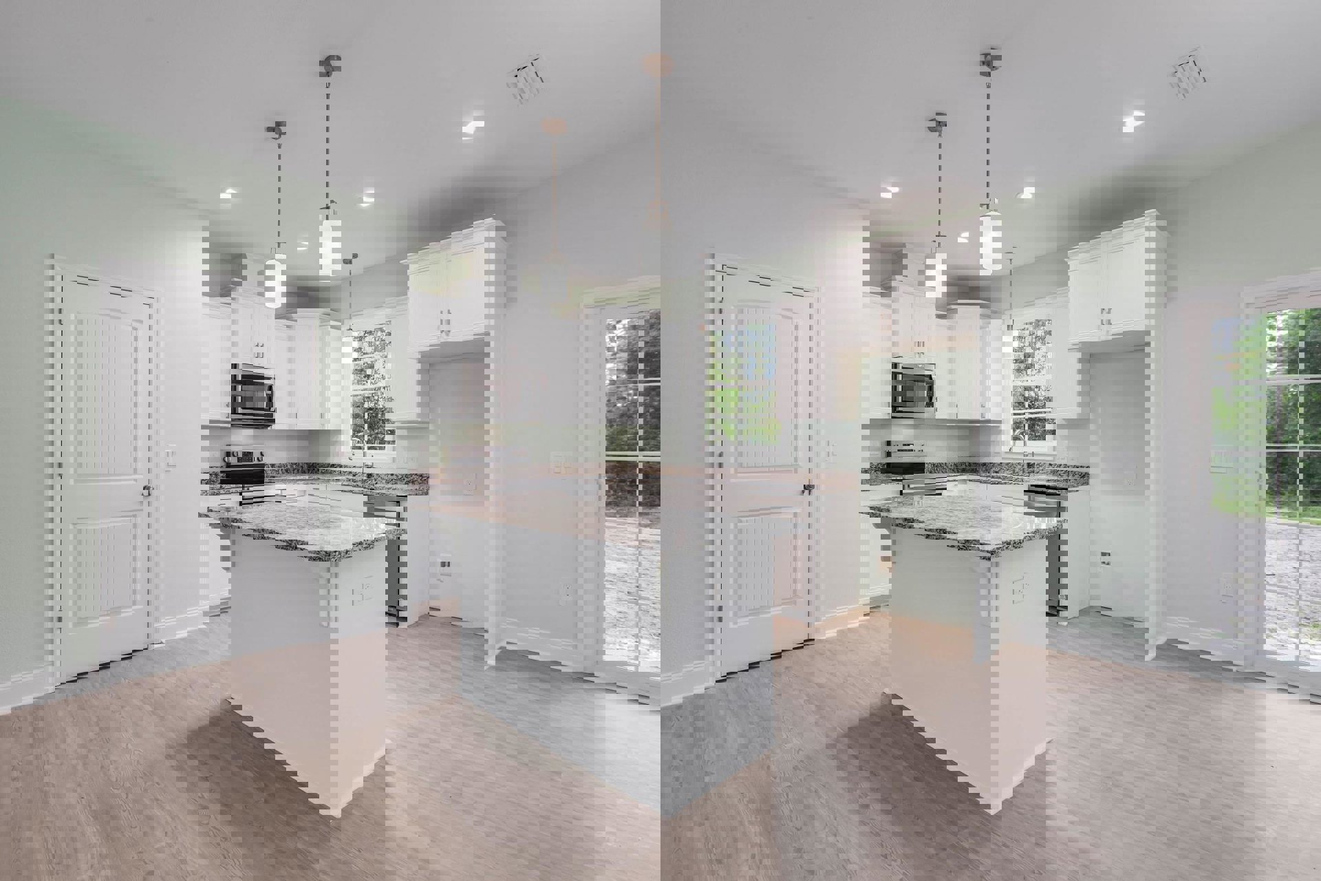 White kitchen with shaker cabinets, granite island countertop, open microwave door, stainless hardware, window overlooking trees, hardwood flooring