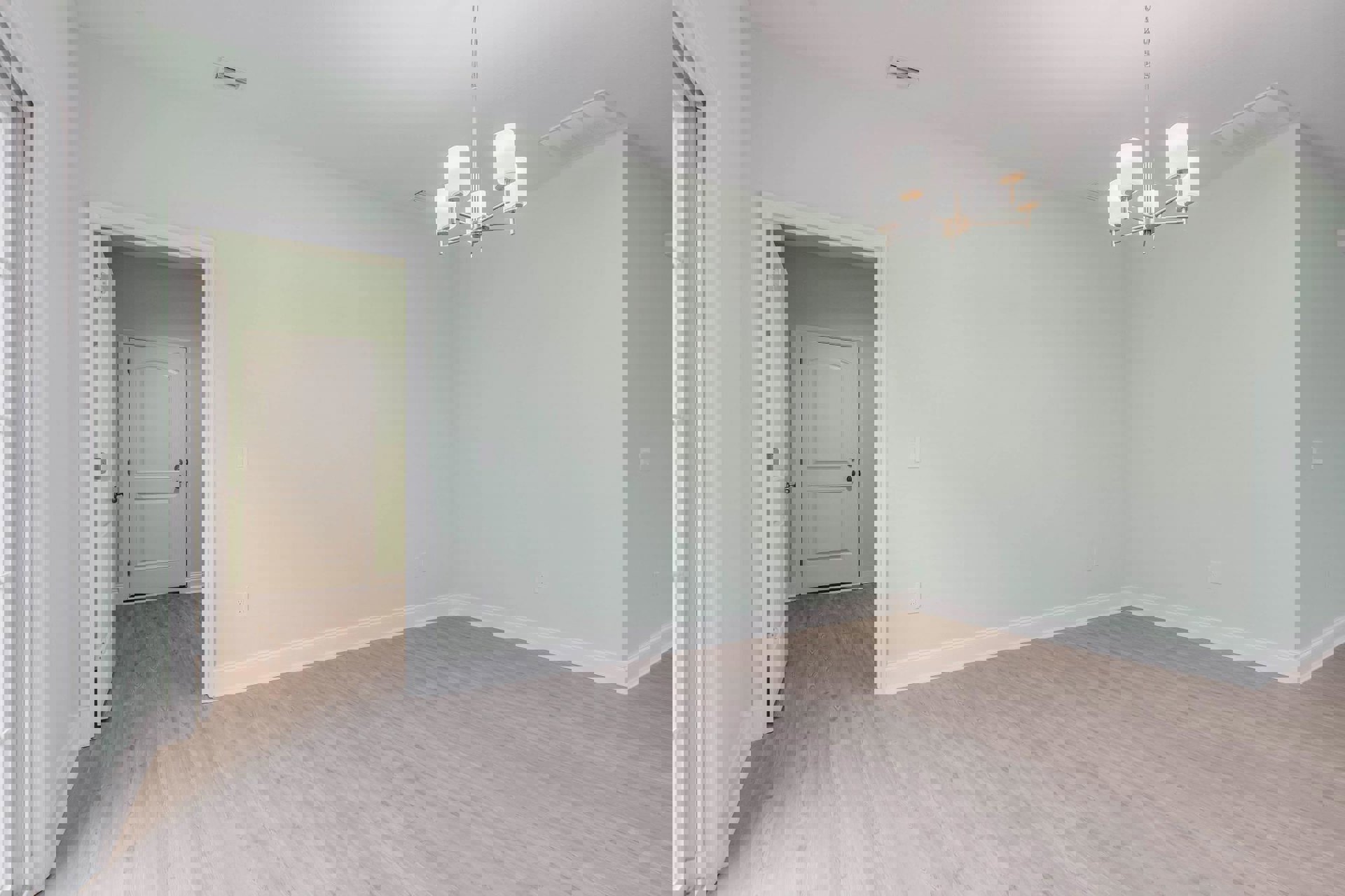 Open room with pale wood flooring, white baseboards, white door with silver handle, and modern chandelier hanging from ceiling.