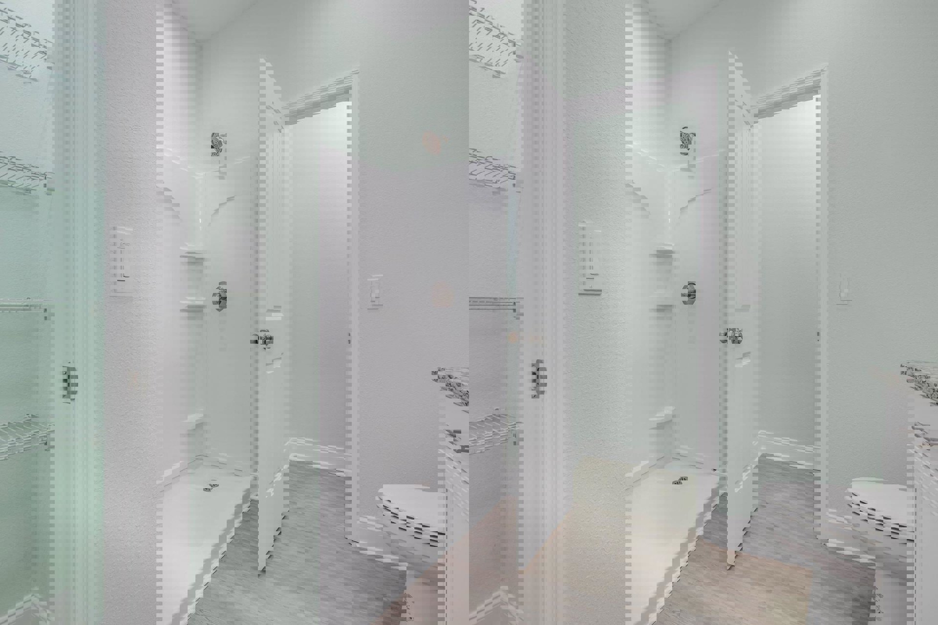 Modern bathroom featuring a tiled shower with floor drain, white toilet, wall-mounted light switch, white shelving with exposed plumbing, and neutral finishes.