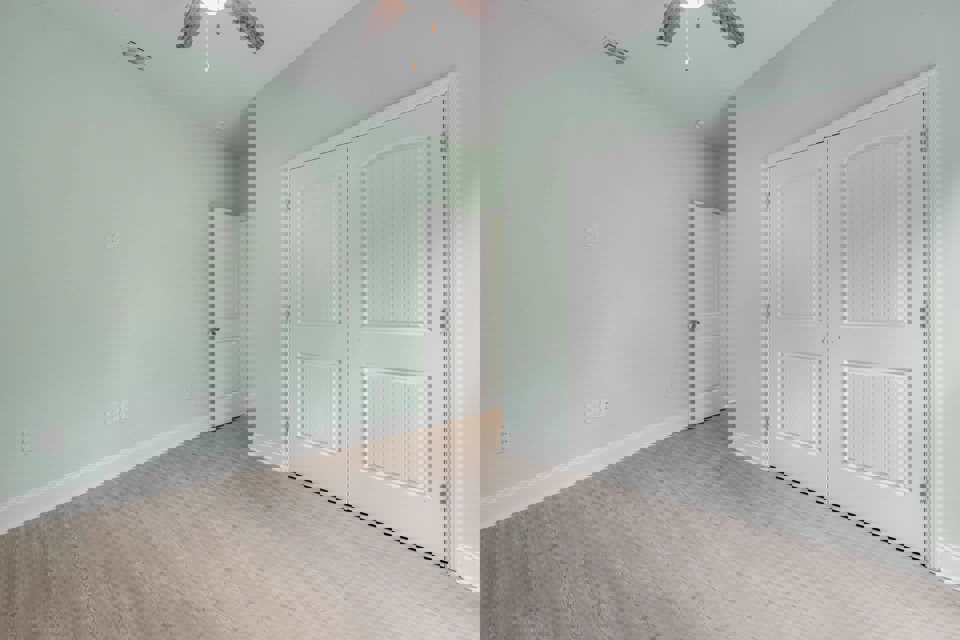 Room with white double doors, silver door knobs, wood laminate flooring, white walls, and ceiling fan with light fixture