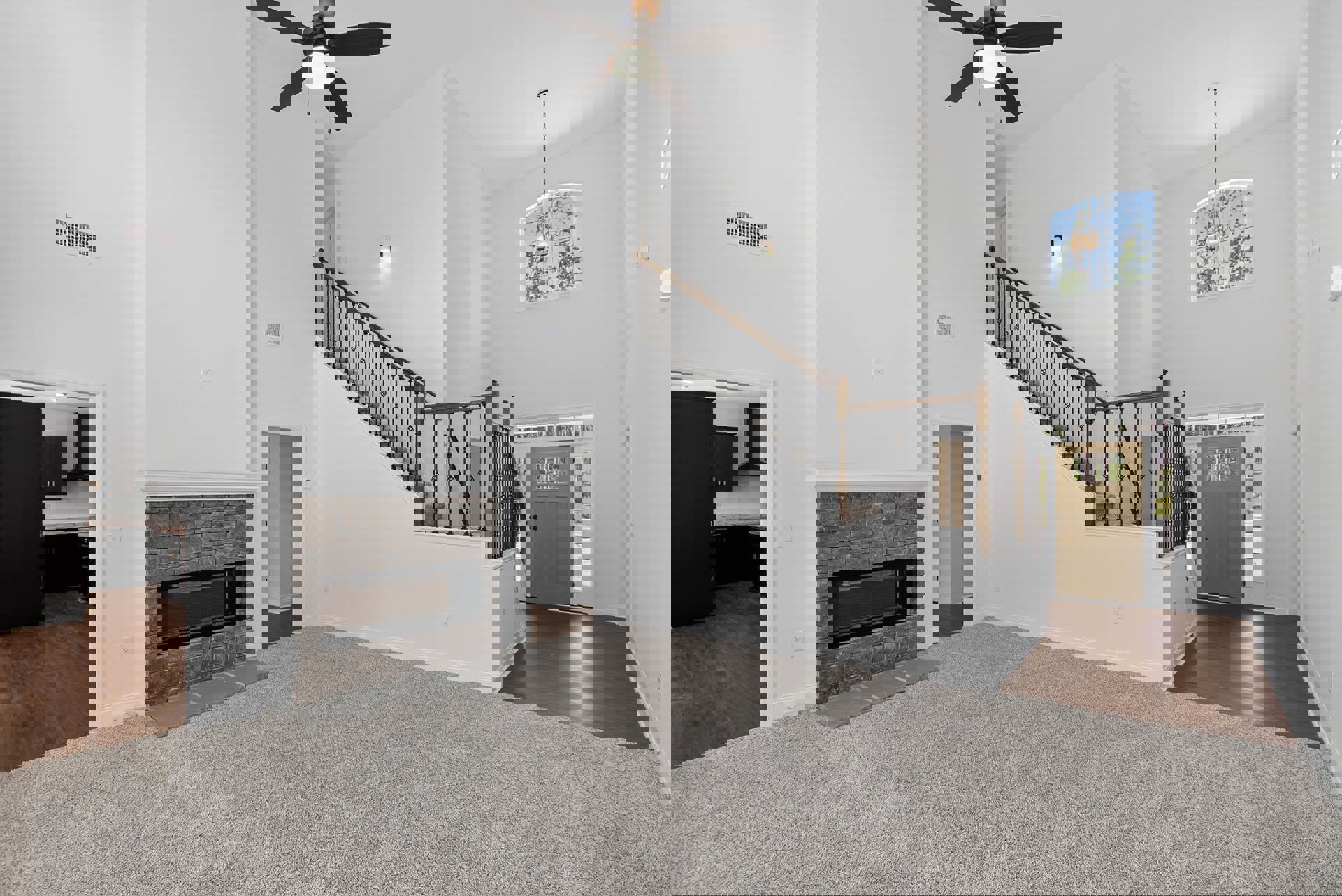 Living room with dark accent wall, fireplace, ceiling fan with light, window, metal-railed staircase, and door with glass inset