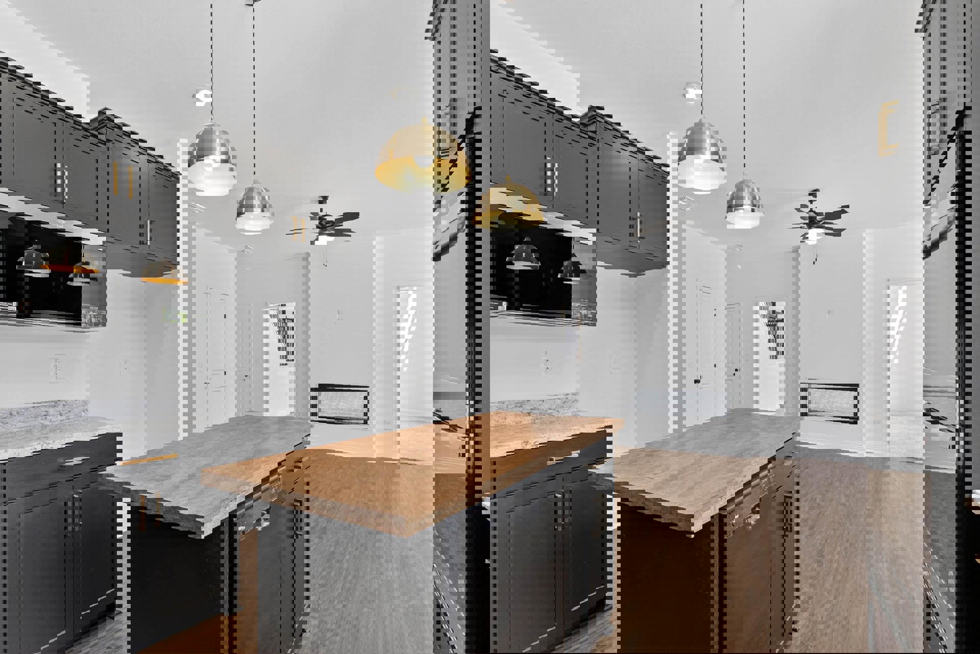 Kitchen with wood island, black and wood countertops, ceiling fan, cabinetry, sink, dishwasher, and light fixture