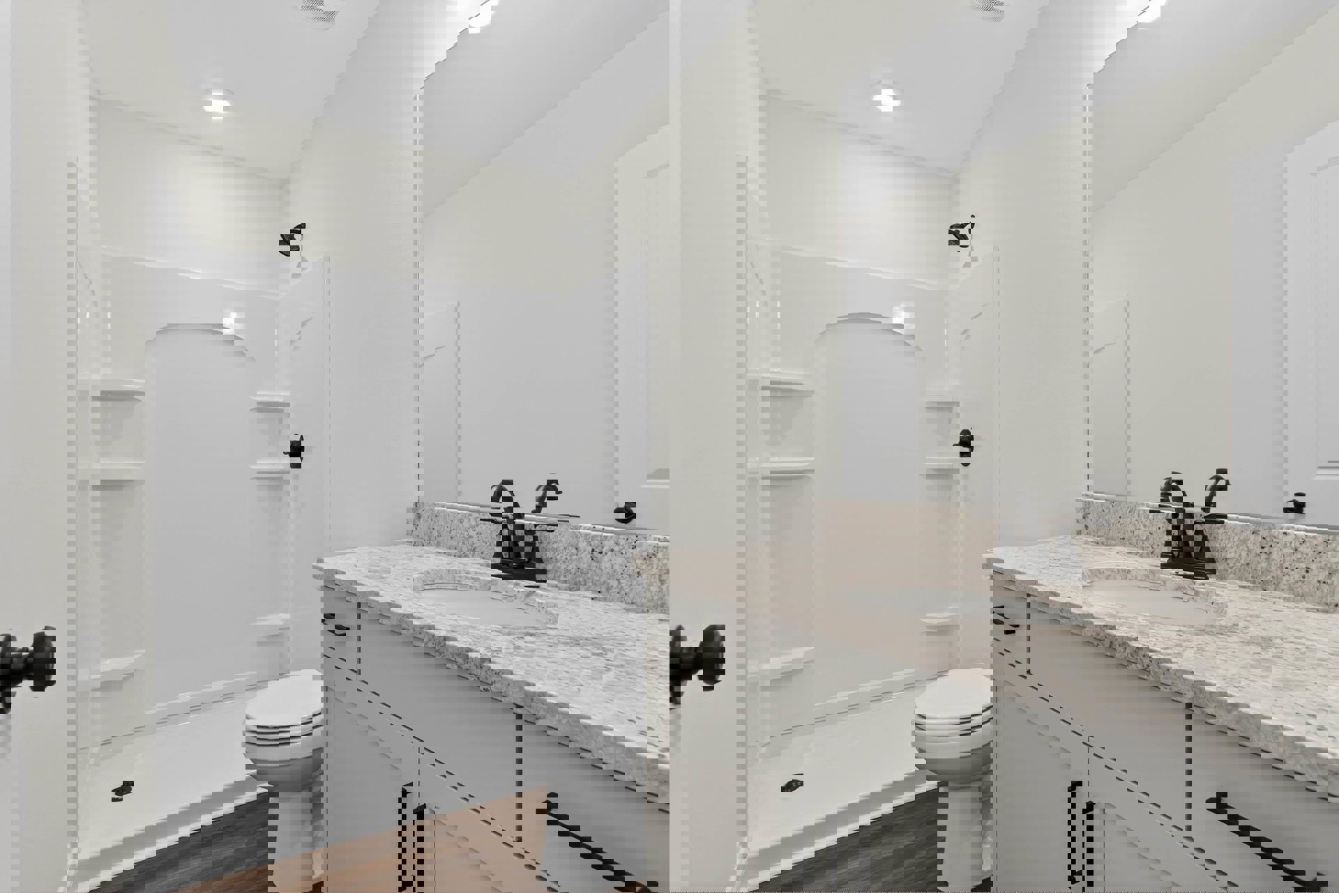 Modern bathroom with white tile walls, black shower head, white sink and faucet, built-in cabinetry, and a close-up view of the toilet