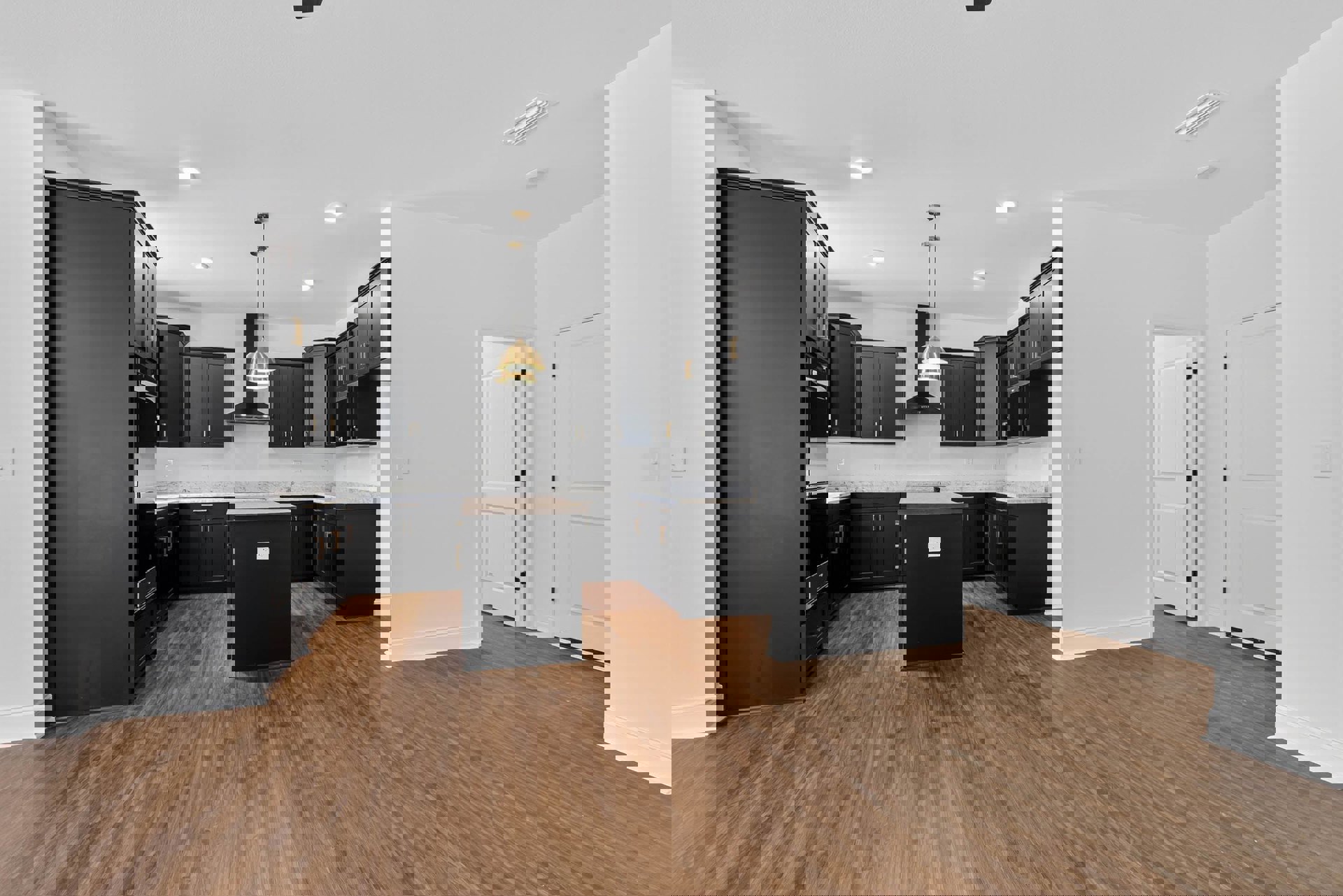 Kitchen with matte black cabinets, light hardwood flooring, white walls, modern black hardware, recessed ceiling lights, and a white door with black handle