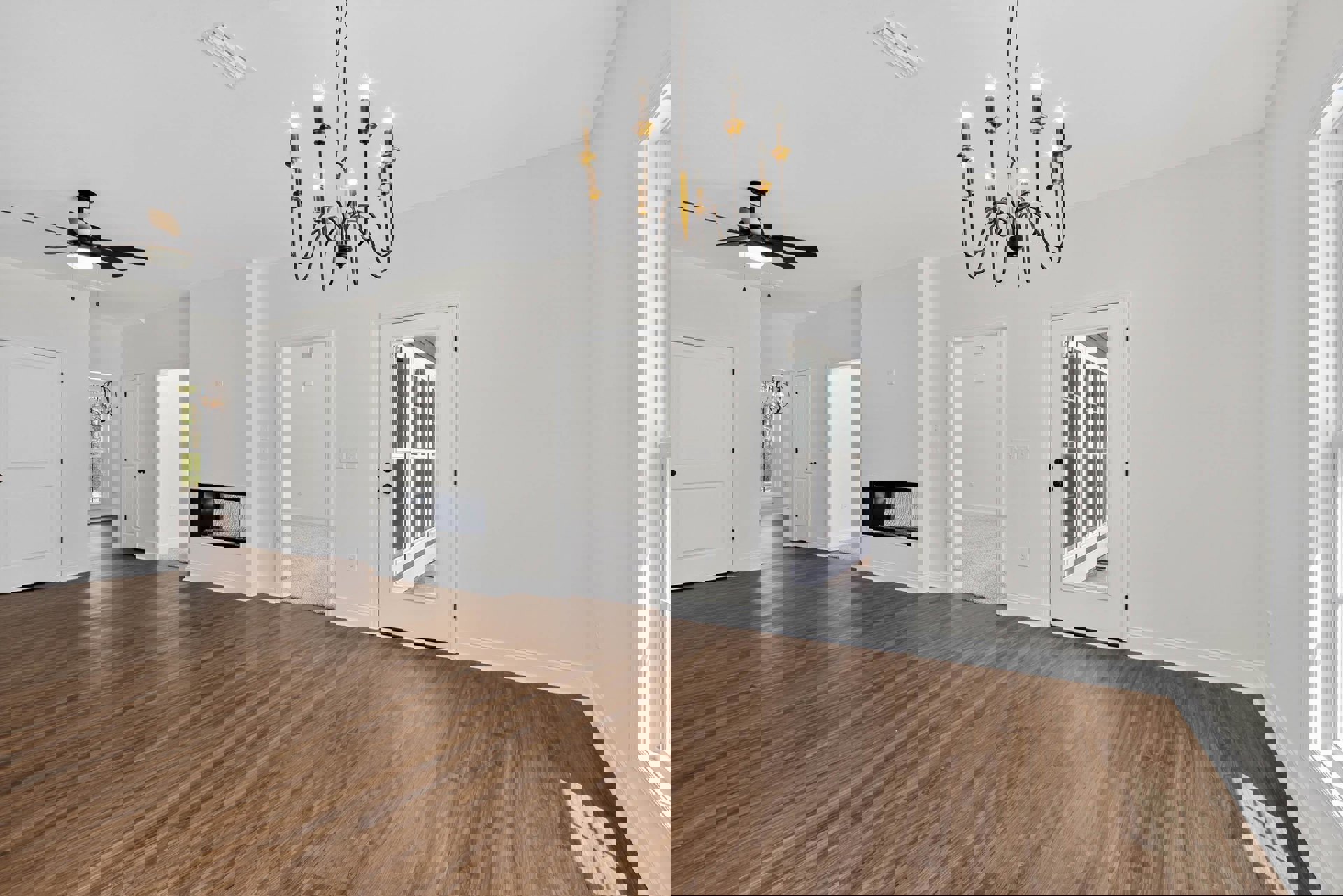 Chandelier with multiple lights hanging in a room featuring hardwood floors, white walls, and a white door with glass panes and a black handle