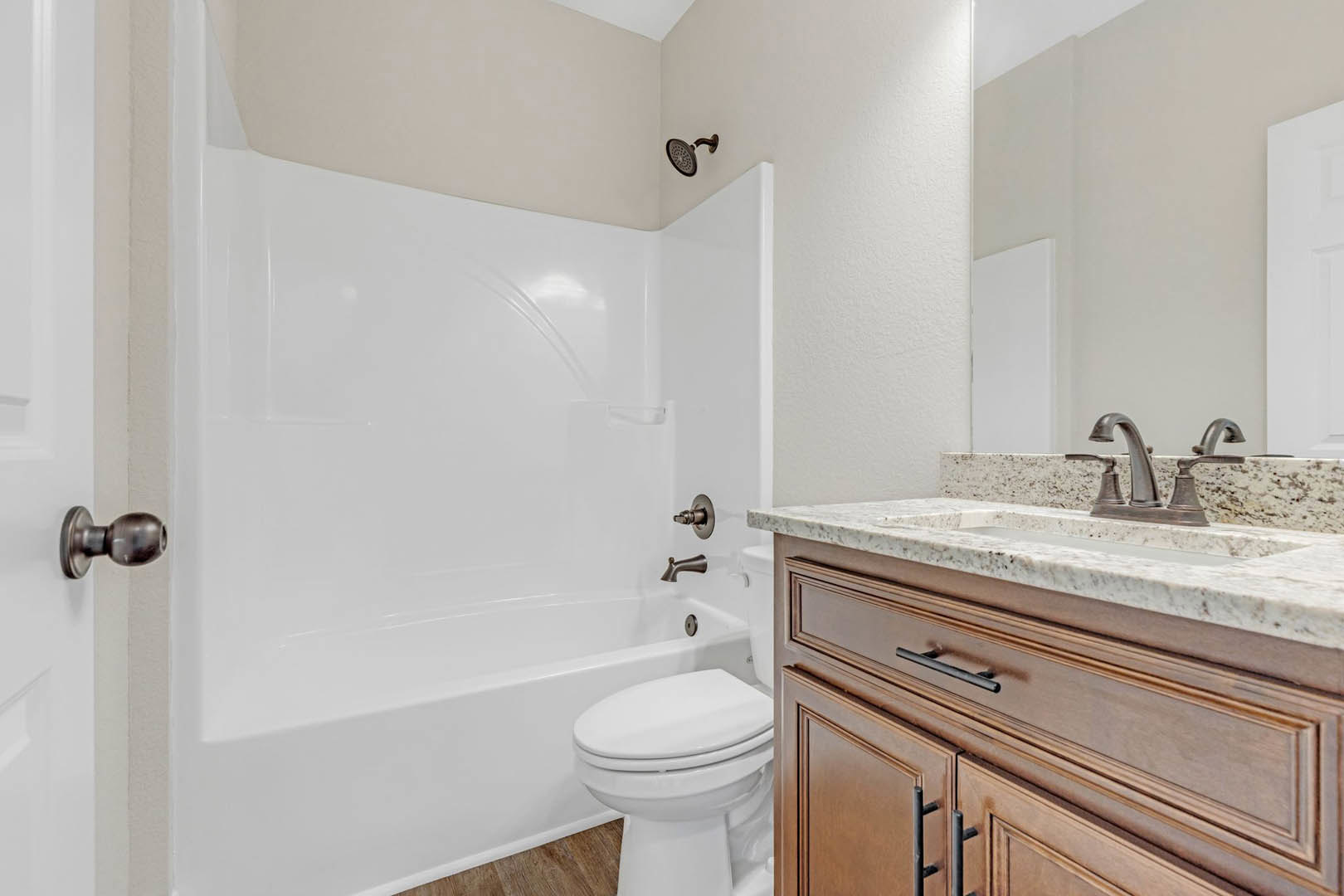 White tile bathroom with modern toilet, rectangular sink on stone countertop, chrome faucet, and built-in cabinetry