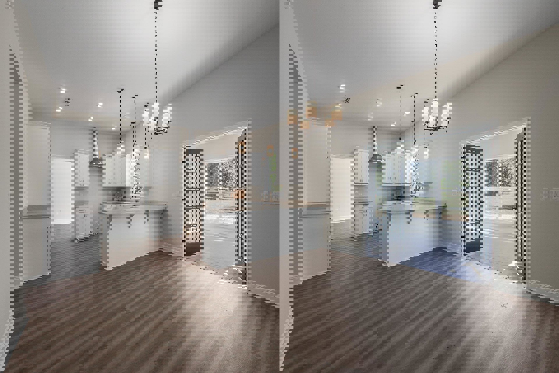 Open-concept kitchen and dining area featuring wood flooring, white cabinetry with a built-in sink, white countertops, and an adjacent open door leading to a room with white walls.