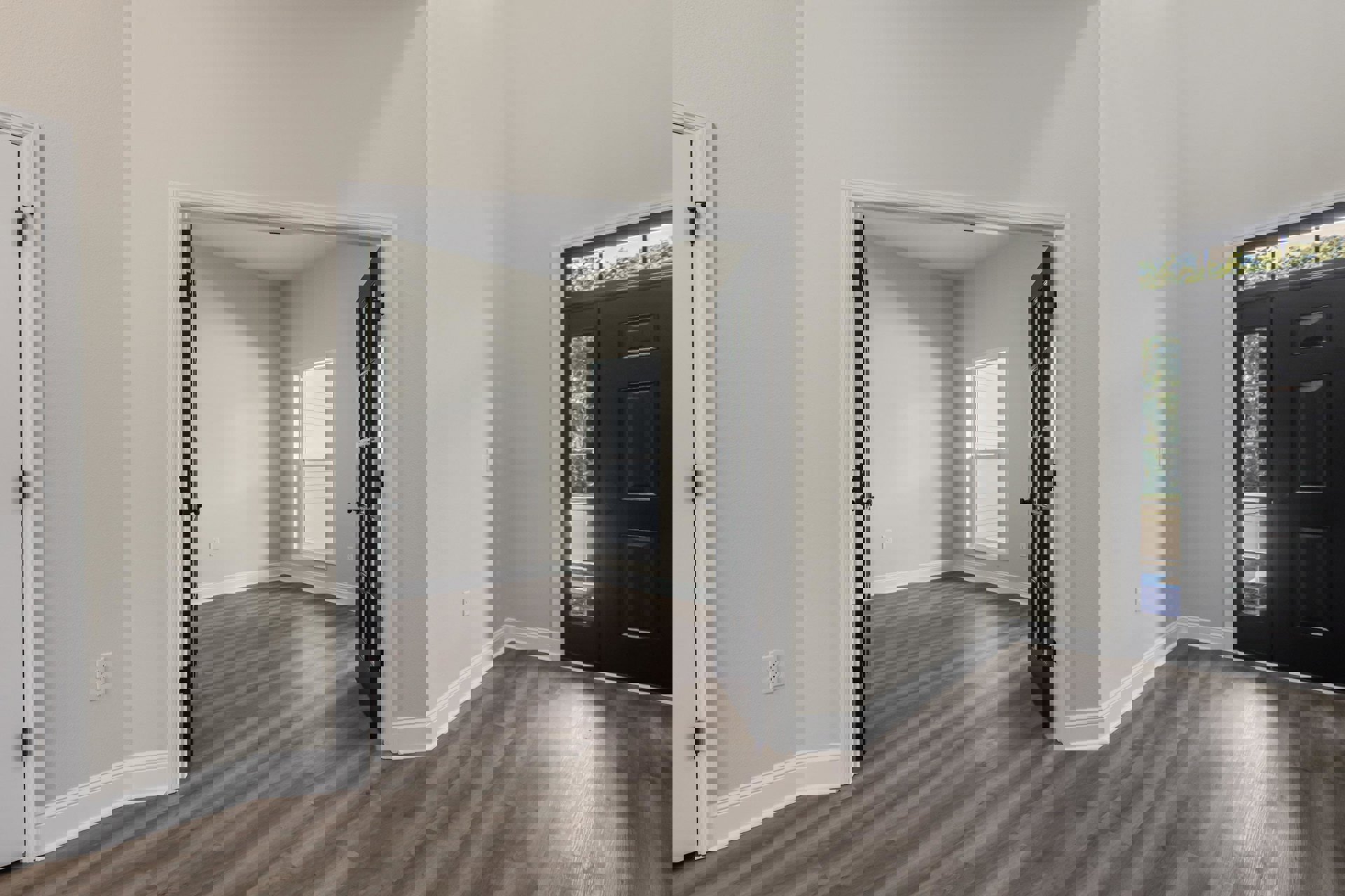 Black paneled door with glass window open to a room featuring white paneled walls, white-framed window, laminate flooring, and visible electrical outlet and door hinge