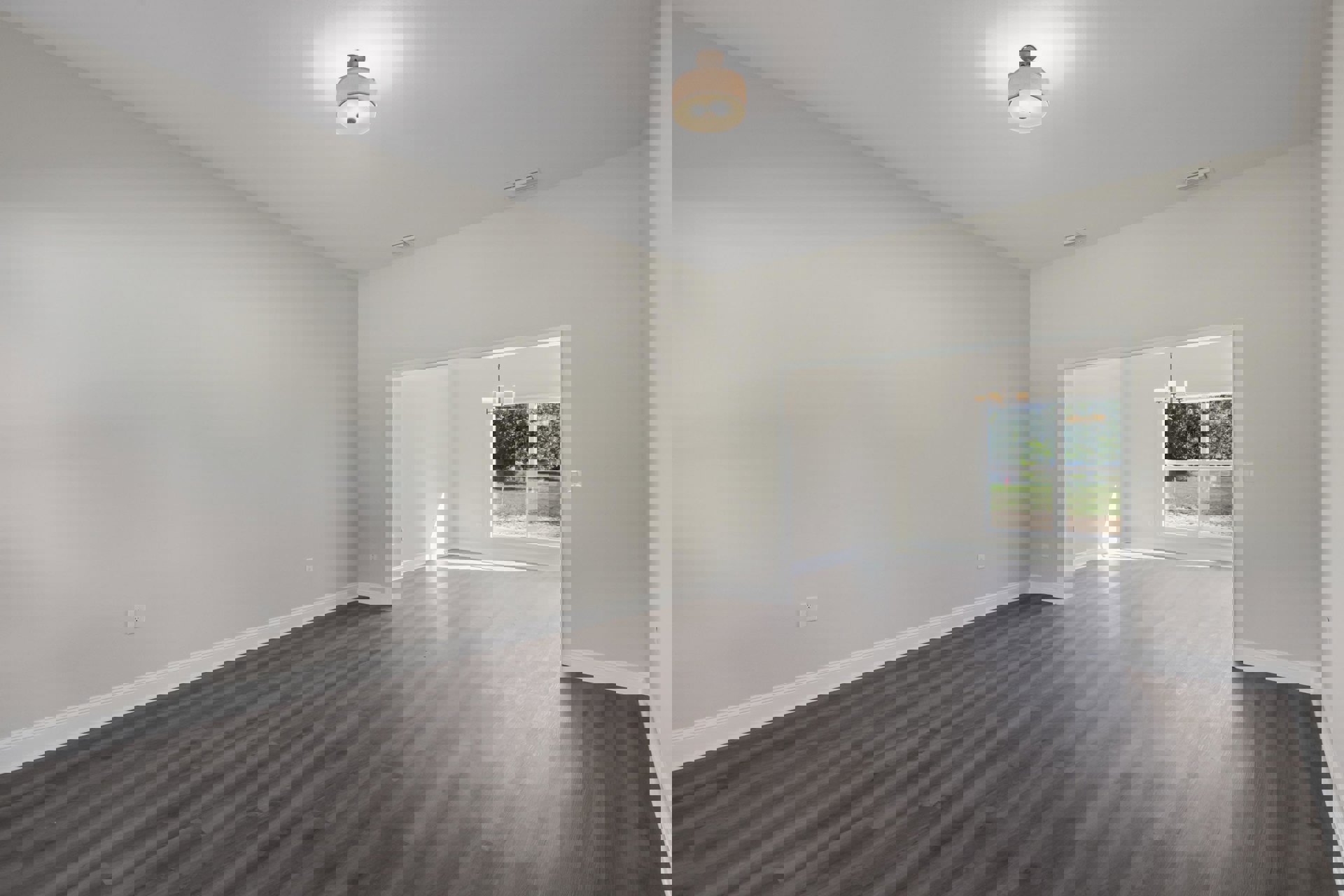 Empty room with natural wood flooring, white walls, large window, and ceiling-mounted light fixture with white shade