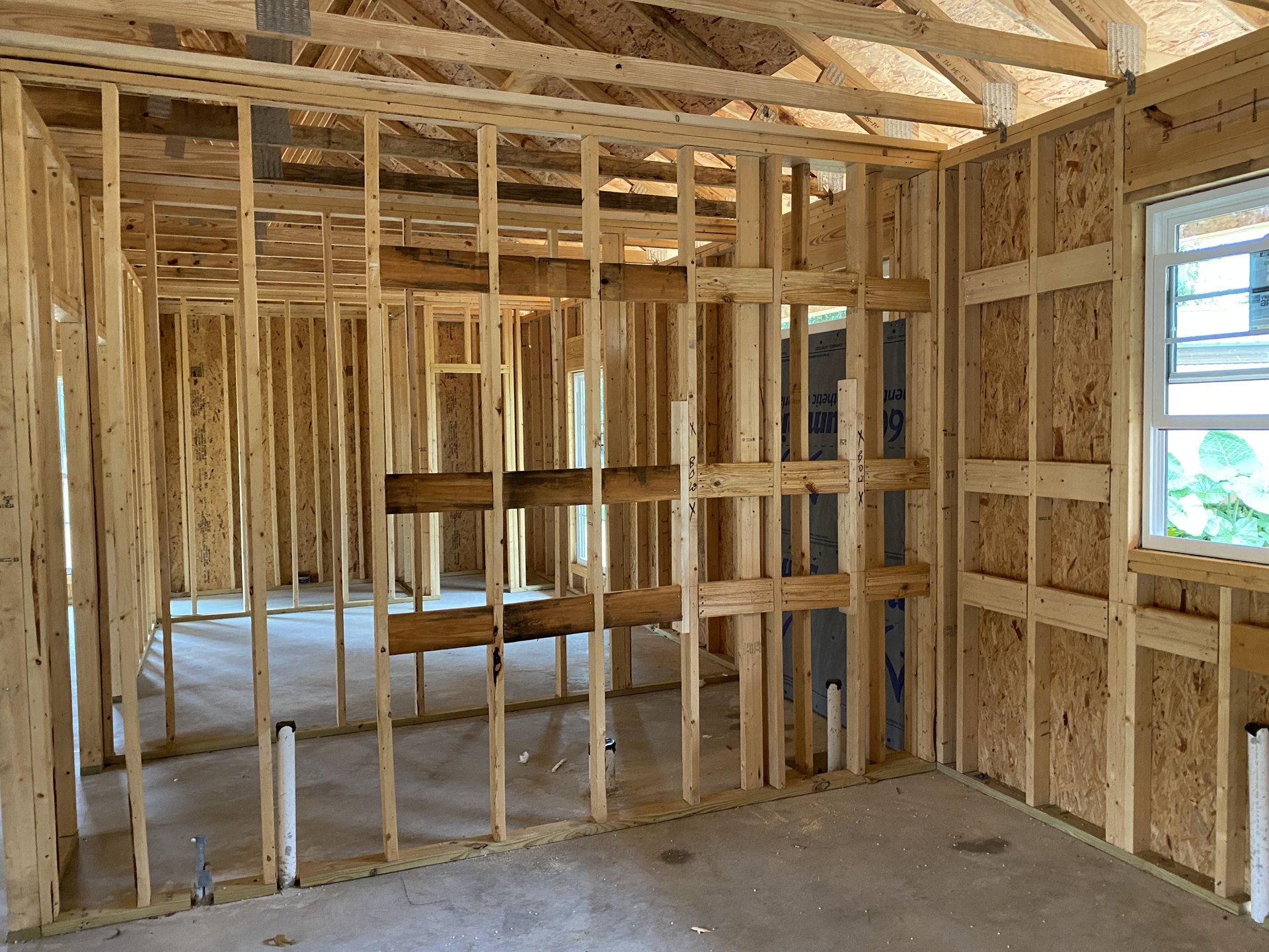Exposed wood ceiling beams, white-framed window, light-colored walls, hardwood floor