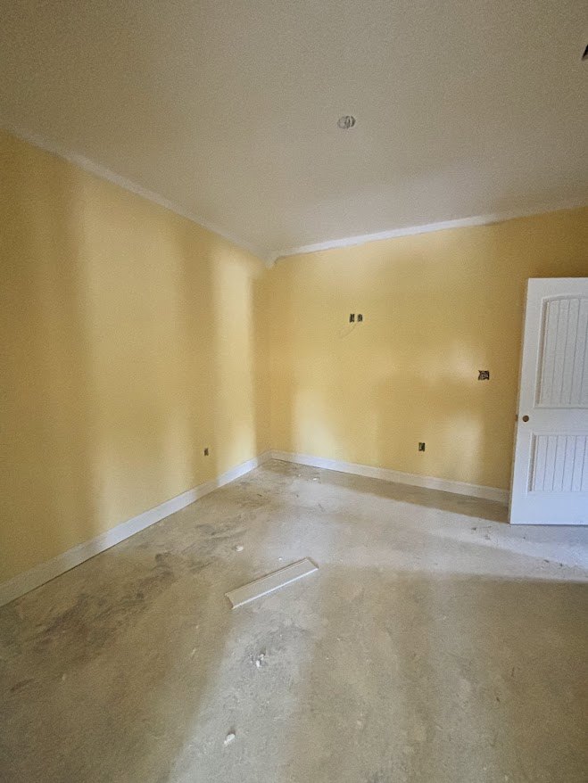 Beige tile flooring, white plaster walls, two white doors, one with a hole, simple ceiling