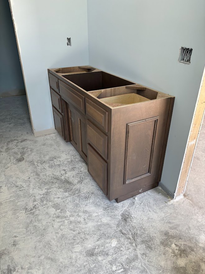 Light wood kitchen cabinets with flat panel doors and drawers, white quartz countertop, neutral tile flooring, and recessed wall niche