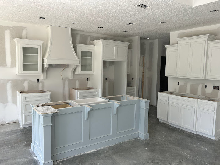 White kitchen with shaker cabinets, quartz countertops, stainless steel appliances, undermount sink, and recessed lighting.
