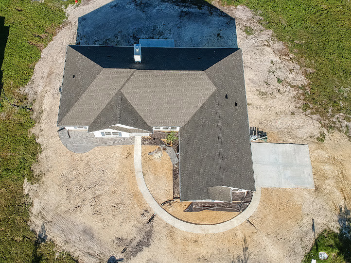 Modern two-story home with light siding, attached garage, concrete driveway, and manicured green lawn