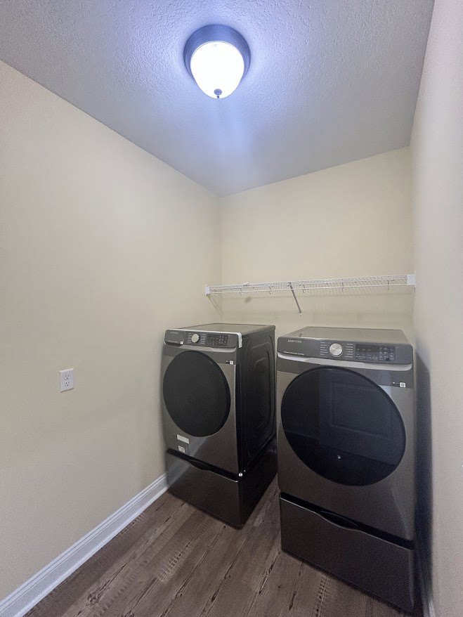 Front-loading washer and dryer set against white walls with tile flooring in a laundry room