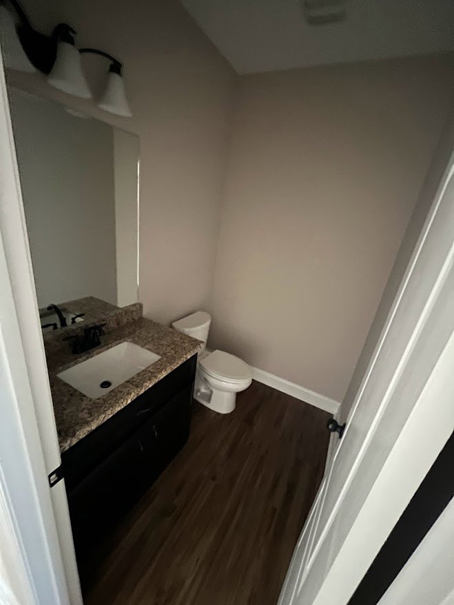Bathroom with white ceramic sink, chrome faucet, and toilet beside light-colored stone countertop; tiled walls and floor with neutral tones.