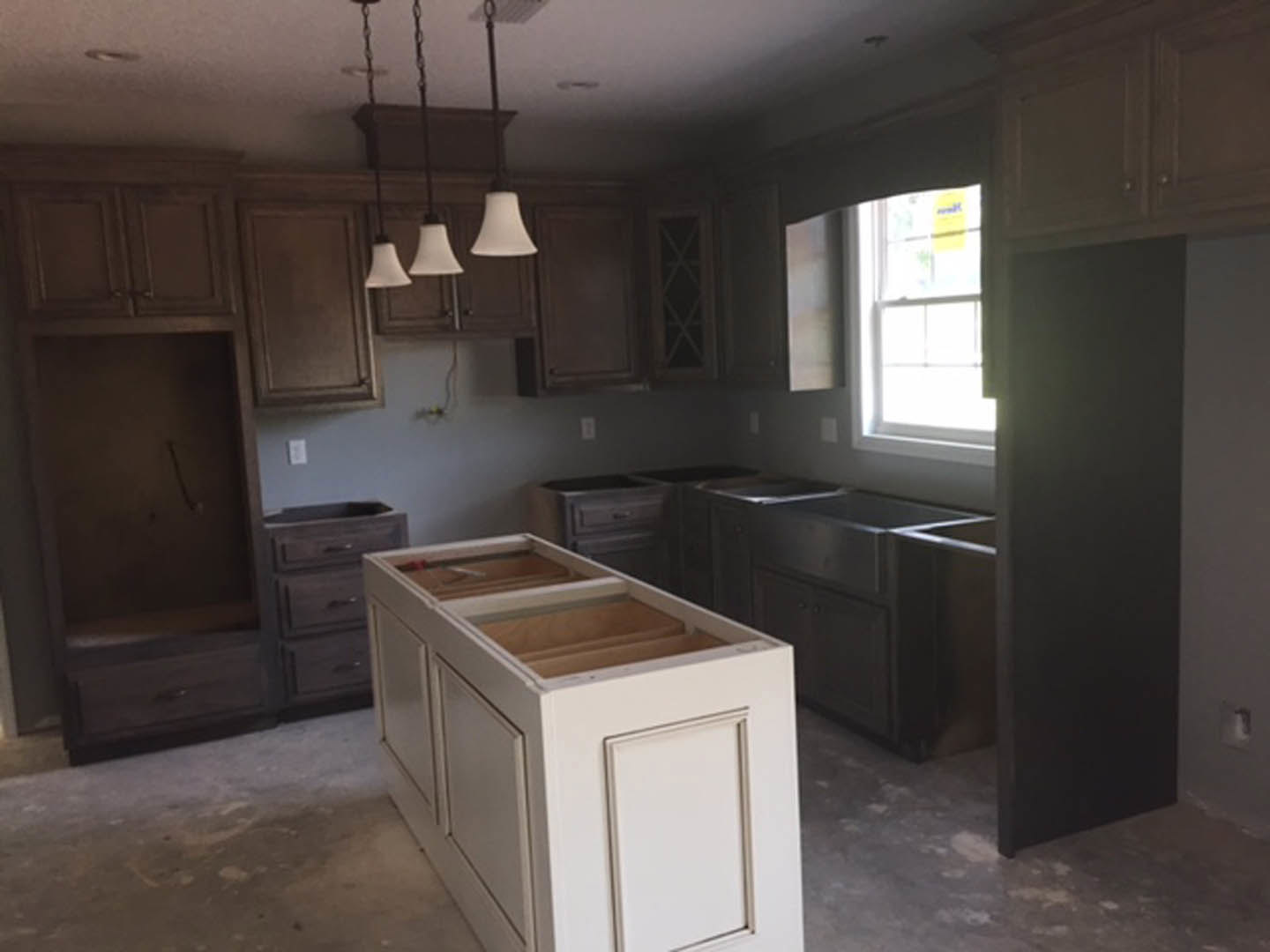 Modern kitchen with white shaker cabinets, quartz countertop, stainless steel sink, pendant lights, and large window