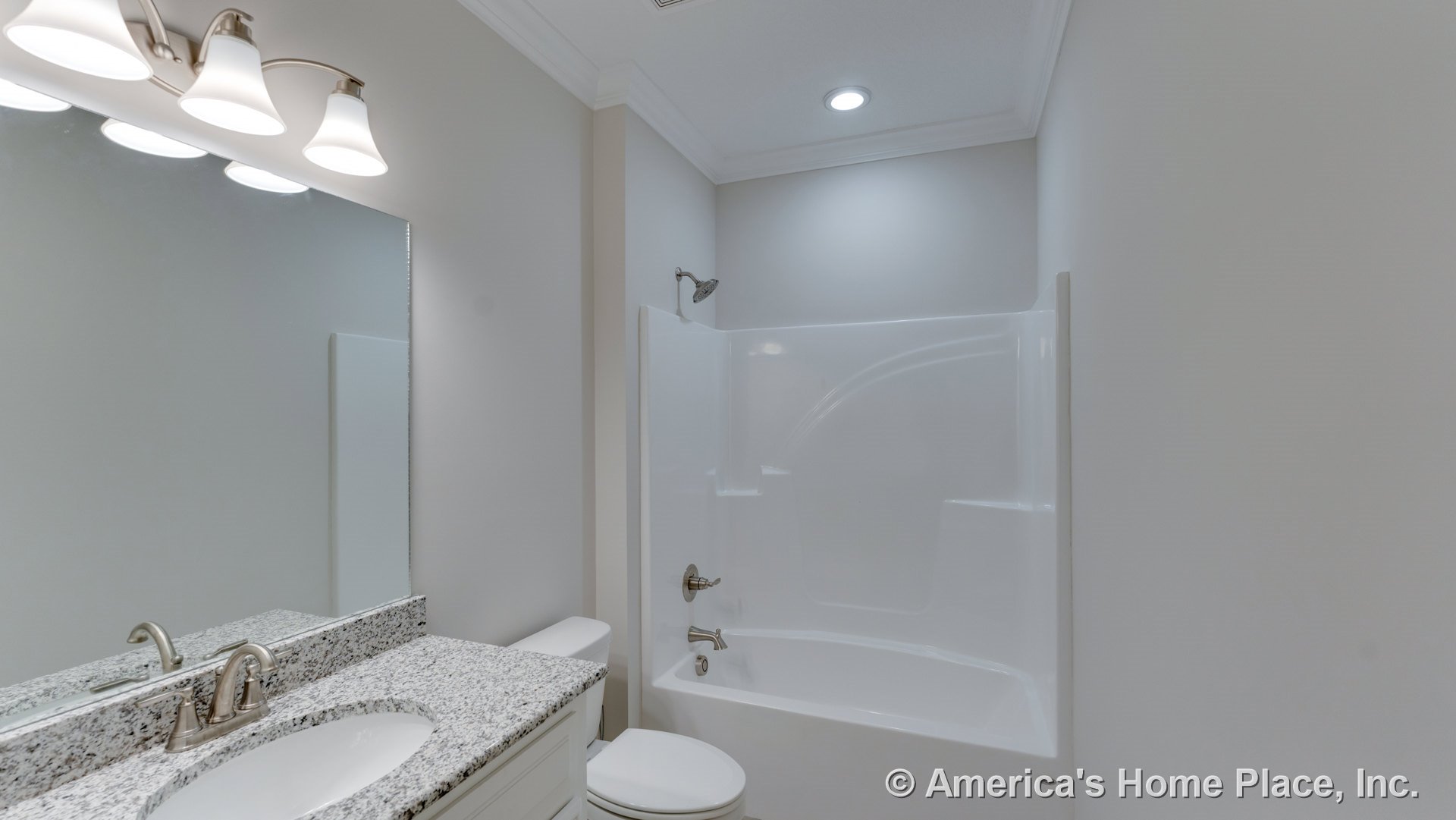 Granite countertop vanity with white cabinetry, chrome faucet, large mirror, fiberglass tub-shower combo, recessed ceiling light, three-light wall fixture, and neutral walls.