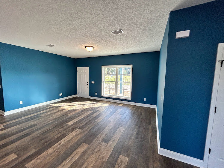 Blue-painted walls, light wood flooring, white ceiling, and a closed door in a residential interior room