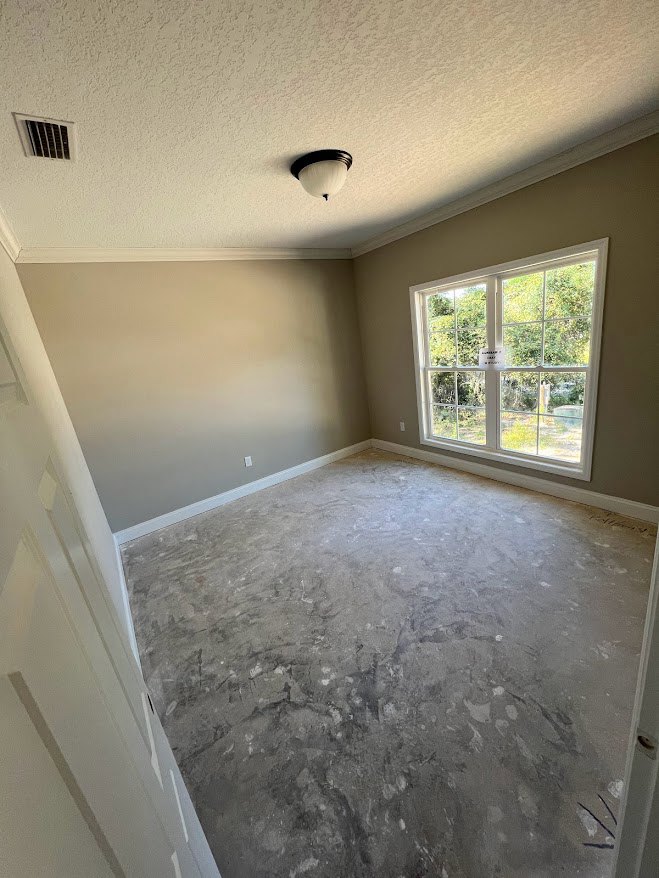 White-walled room with a large window featuring a sign, concrete floor, black and white pendant light fixture, and wall vent