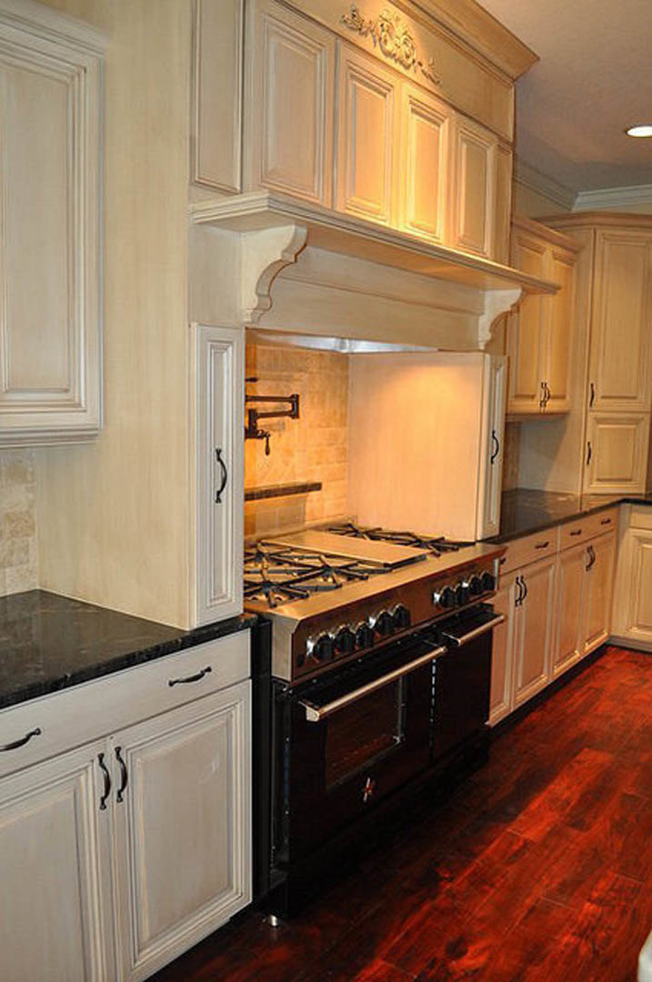 White shaker cabinets, stainless steel stove, quartz countertops, subway tile backsplash, and brushed nickel hardware in a modern kitchen.
