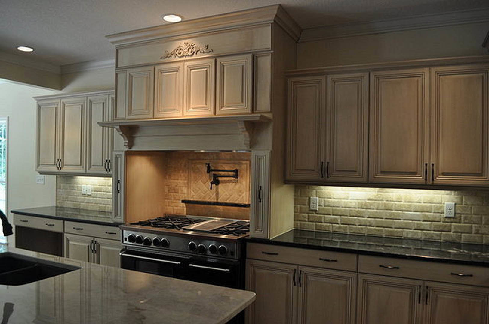 Modern kitchen featuring stainless steel stove and oven, white cabinetry, quartz countertops, and dark wood dining table