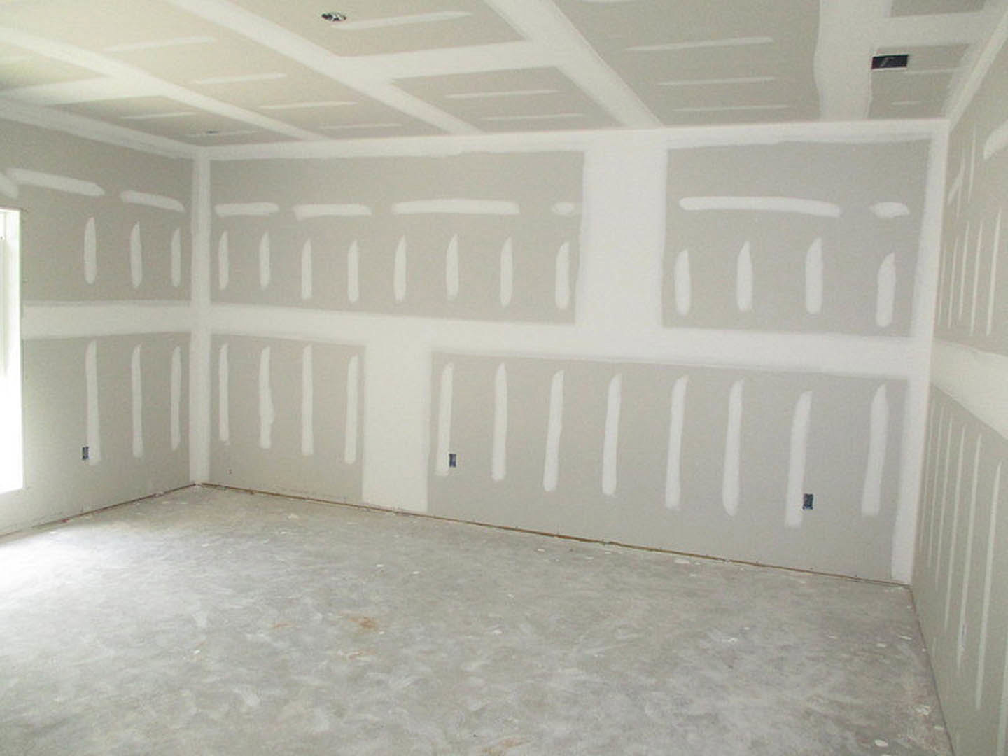 White-painted walls, smooth plaster ceiling, and polished concrete flooring in a modern residential room