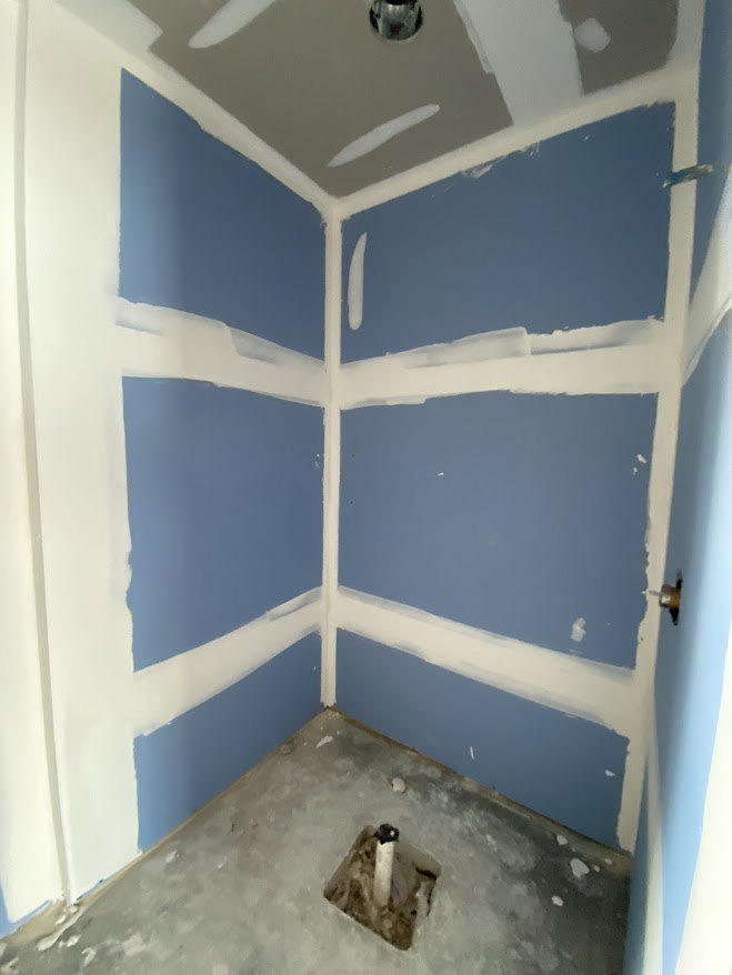 Blue walls with bold white stripes, smooth plaster finish, light-colored composite flooring, white ceiling, modern interior detailing
