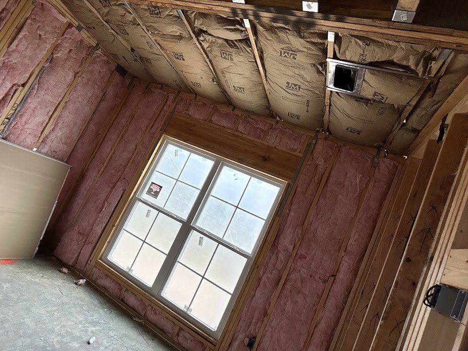 Bright room with white plaster walls, red accent wall, square-paned window, and ceiling fixture.