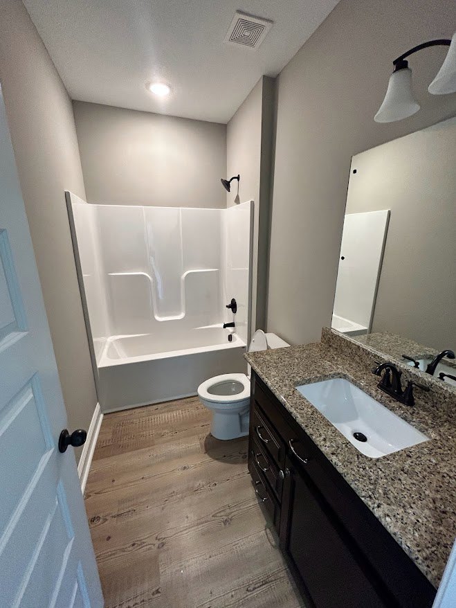 Bathroom with white tile walls, modern white sink with black drain and chrome faucet, white toilet with seat down, light-colored countertop, and minimalistic fixtures.