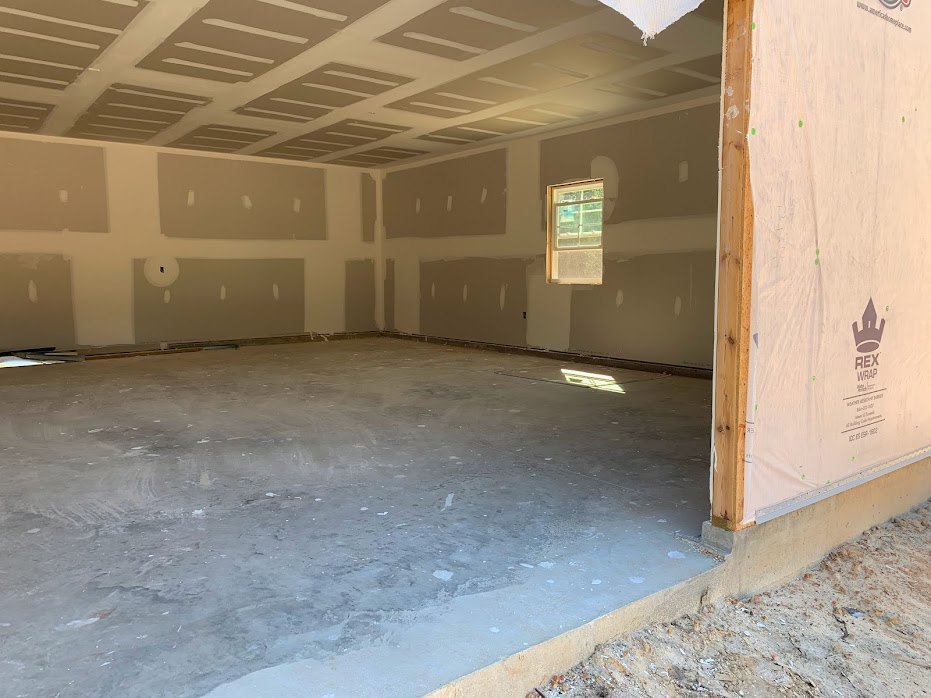 A room with a window and concrete floor.