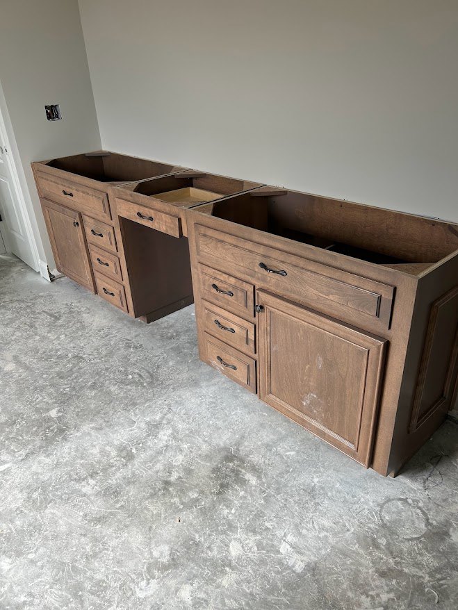 Light wood kitchen cabinetry with stone countertops, stainless steel drawer pulls, and neutral tile flooring