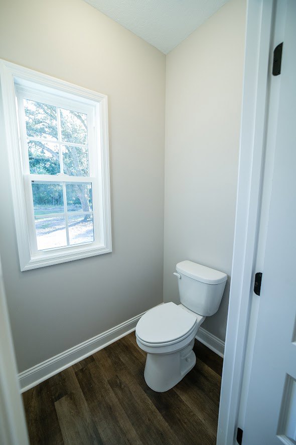 White toilet with closed lid set against light-colored tiled wall in modern bathroom