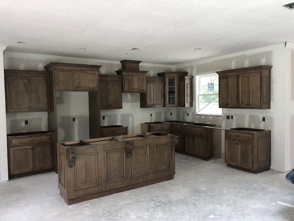 Kitchen featuring wood cabinets, white ceiling, brown cabinetry with drawers, white walls, window with a sign, and a countertop with a sink and home appliances