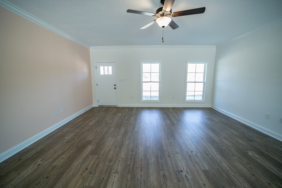 Ceiling fan with light fixture, wood flooring, white door with glass window, white-framed window, neutral walls